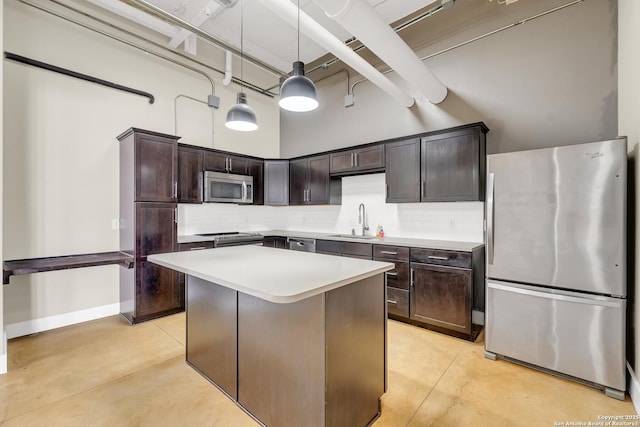 kitchen with a center island, sink, stainless steel appliances, a high ceiling, and pendant lighting