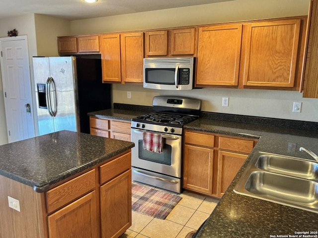 kitchen with sink, light tile patterned floors, and stainless steel appliances