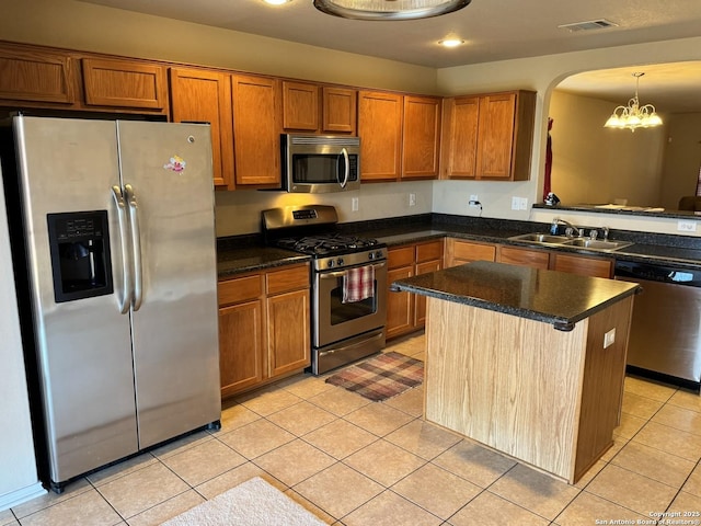 kitchen with sink, hanging light fixtures, stainless steel appliances, a notable chandelier, and light tile patterned floors