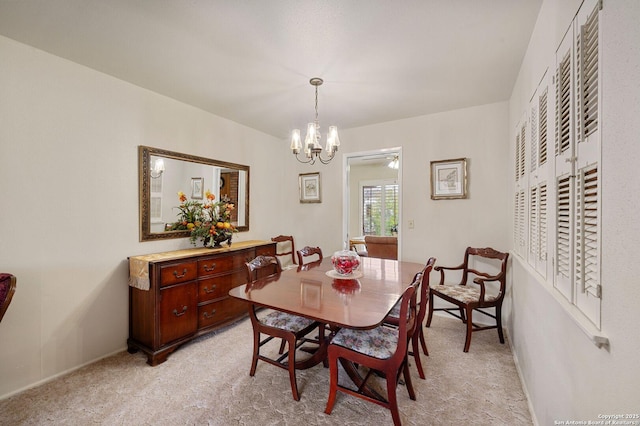 carpeted dining area featuring a notable chandelier