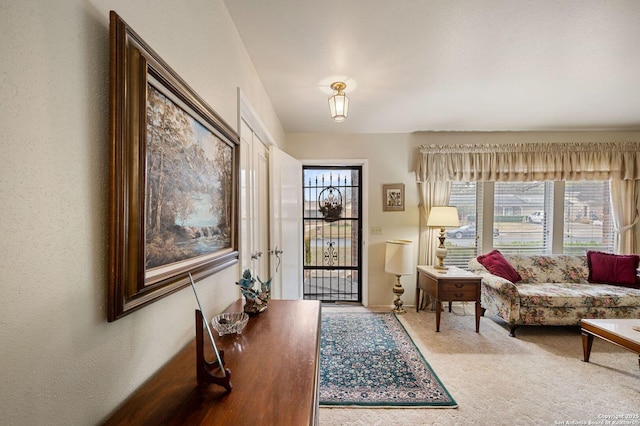 carpeted foyer featuring plenty of natural light