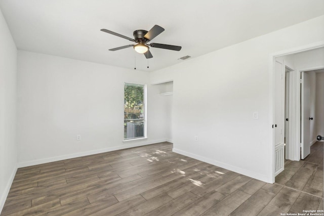 spare room with ceiling fan and dark hardwood / wood-style floors