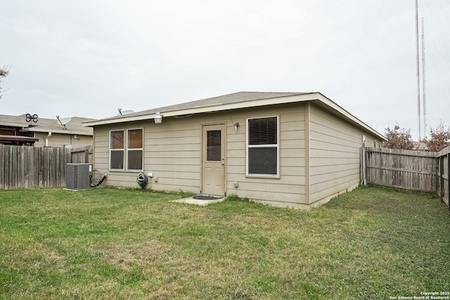 back of house featuring a yard and central AC unit