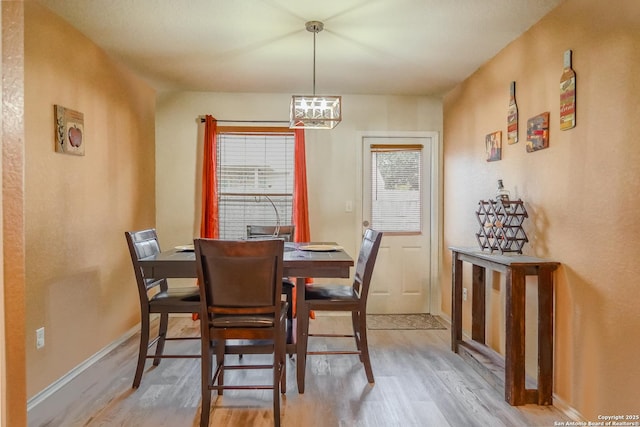 dining area featuring light hardwood / wood-style floors and a notable chandelier