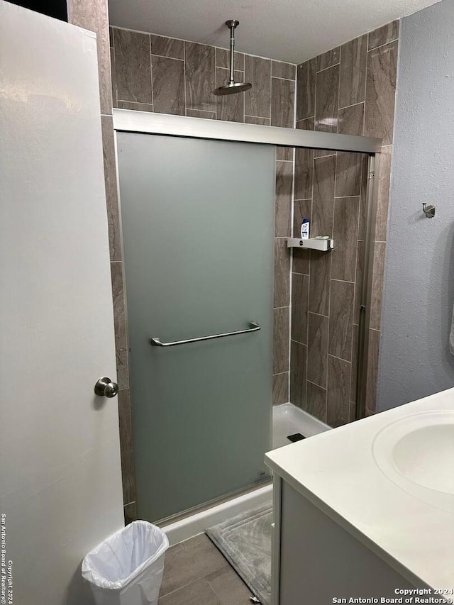 bathroom featuring tile patterned flooring, vanity, and walk in shower