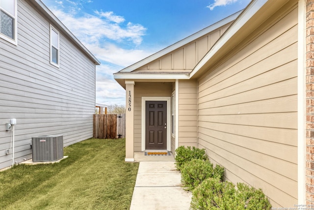 entrance to property featuring a lawn and cooling unit