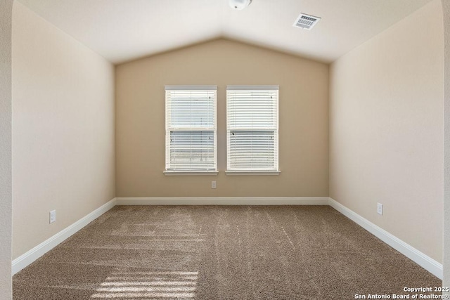 empty room featuring carpet flooring and lofted ceiling