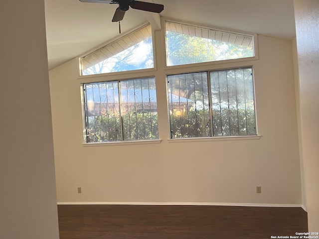 empty room featuring ceiling fan, dark hardwood / wood-style flooring, and vaulted ceiling