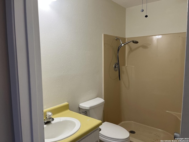 bathroom featuring vanity, toilet, and walk in shower