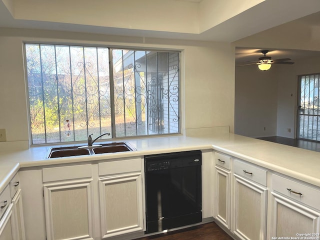 kitchen with kitchen peninsula, dark hardwood / wood-style flooring, ceiling fan, sink, and black dishwasher