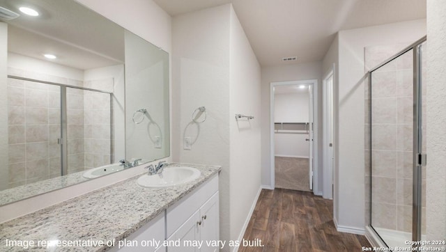 bathroom with hardwood / wood-style flooring, vanity, and a shower with shower door