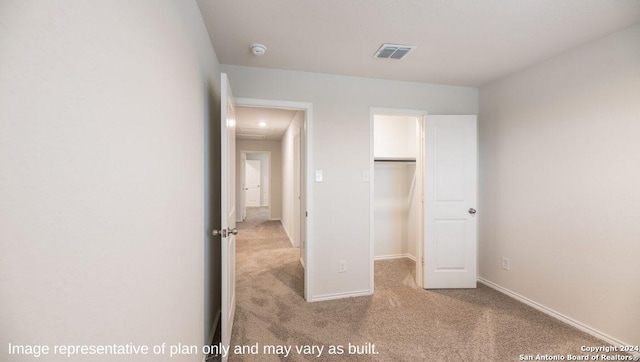 unfurnished bedroom featuring a closet and light colored carpet