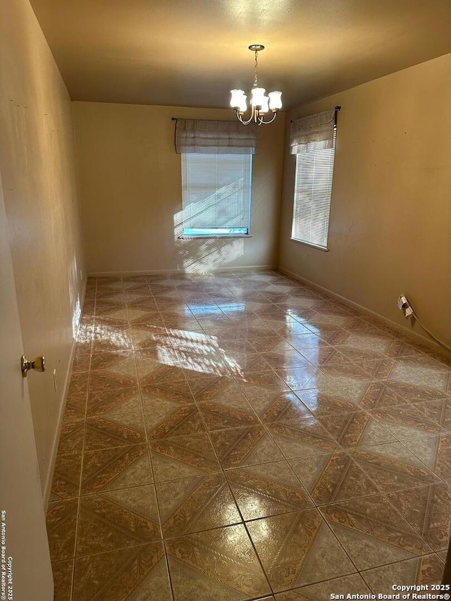 unfurnished room featuring an inviting chandelier