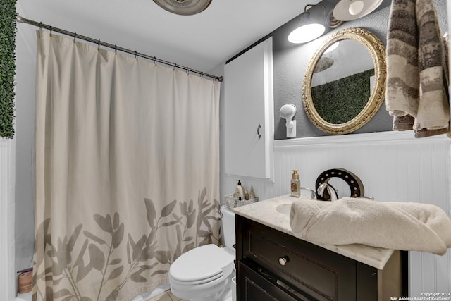 bathroom featuring walk in shower, vanity, and toilet