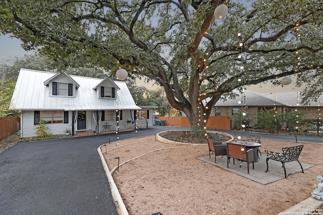 view of front of home featuring a fire pit, a porch, and a patio area