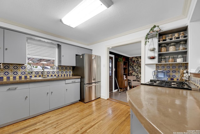 kitchen with stainless steel fridge, tasteful backsplash, a textured ceiling, sink, and black gas cooktop