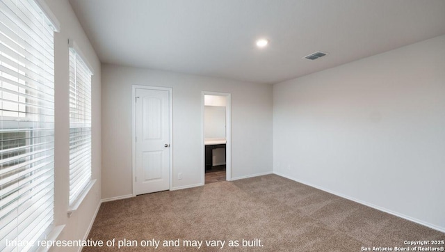 unfurnished bedroom featuring carpet, ensuite bath, a closet, and multiple windows