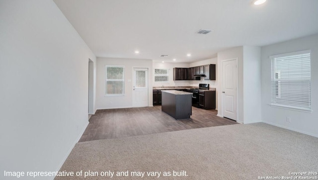 kitchen with carpet flooring, dark brown cabinetry, a center island, and stainless steel range oven