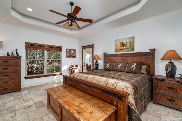 bedroom with a raised ceiling and ceiling fan