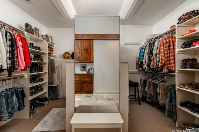 walk in closet featuring light colored carpet