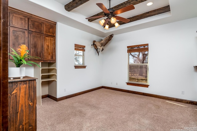 unfurnished room featuring beam ceiling, light colored carpet, a raised ceiling, and ceiling fan