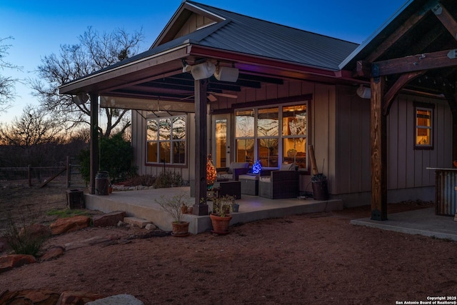 back house at dusk featuring a patio area