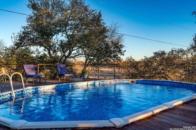 view of swimming pool with a deck