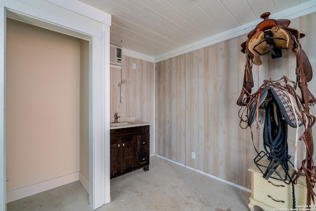 interior space with wooden walls, vanity, concrete floors, and wooden ceiling