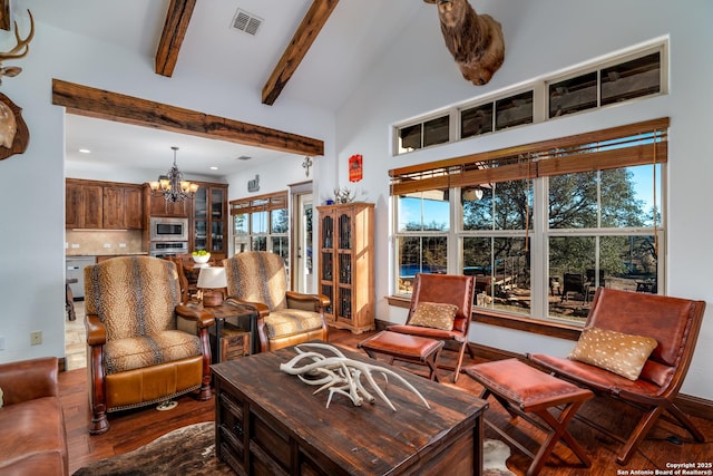 living room with beam ceiling, high vaulted ceiling, dark wood-type flooring, and an inviting chandelier