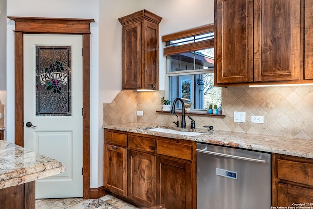 kitchen with backsplash, light stone countertops, dishwasher, and sink