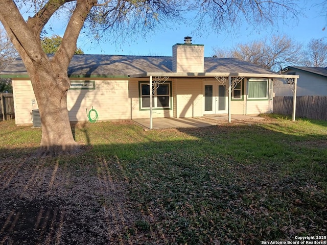 rear view of house with french doors, central AC, a patio area, and a lawn