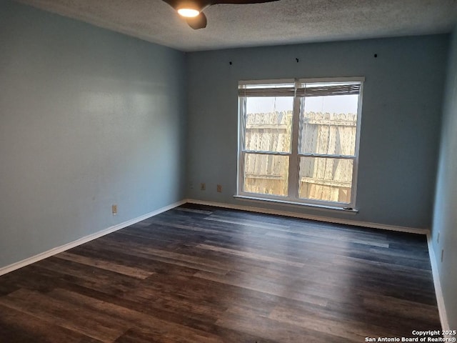 empty room featuring dark wood-type flooring, ceiling fan, and a textured ceiling