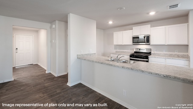 kitchen with sink, light stone counters, dark hardwood / wood-style flooring, white cabinets, and appliances with stainless steel finishes