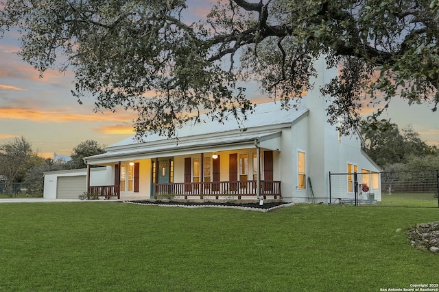 view of front of property with a porch, a garage, and a lawn