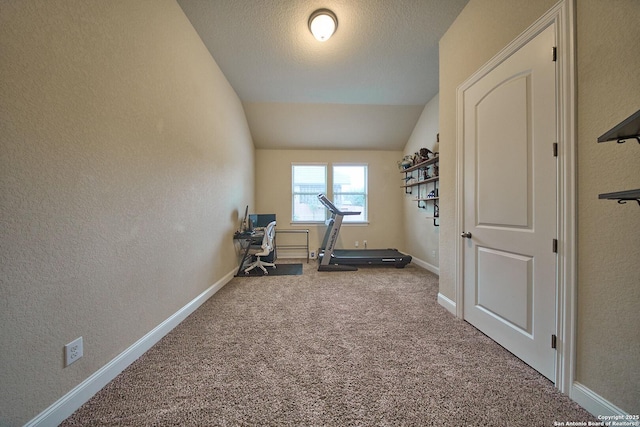 exercise area featuring carpet, a textured ceiling, and vaulted ceiling