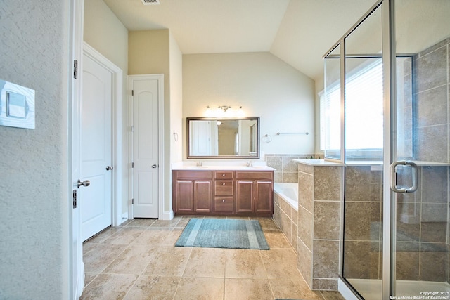 bathroom featuring vanity, vaulted ceiling, and independent shower and bath