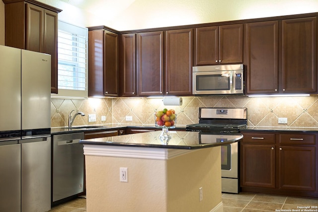 kitchen featuring a center island, sink, light tile patterned floors, appliances with stainless steel finishes, and tasteful backsplash