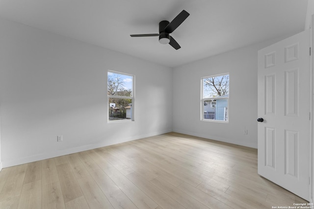 empty room featuring light wood-type flooring, plenty of natural light, and ceiling fan