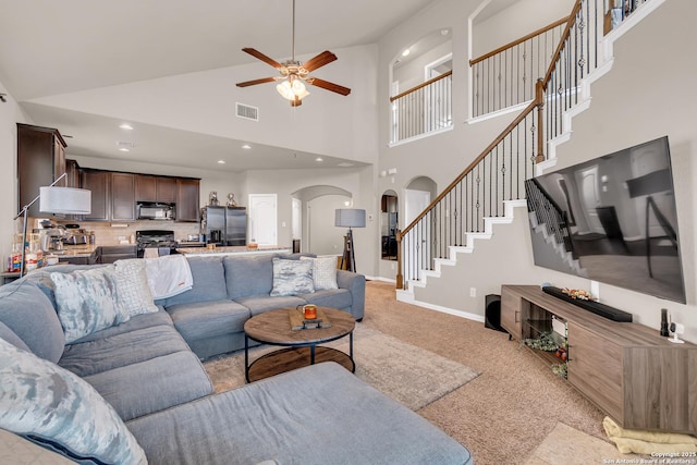 living room with ceiling fan and a high ceiling