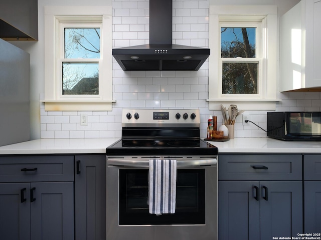 kitchen with stainless steel range with electric stovetop, backsplash, gray cabinetry, and ventilation hood