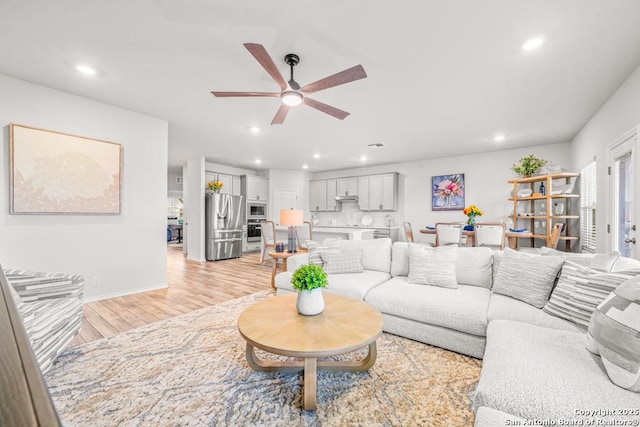 living room featuring ceiling fan and light hardwood / wood-style flooring