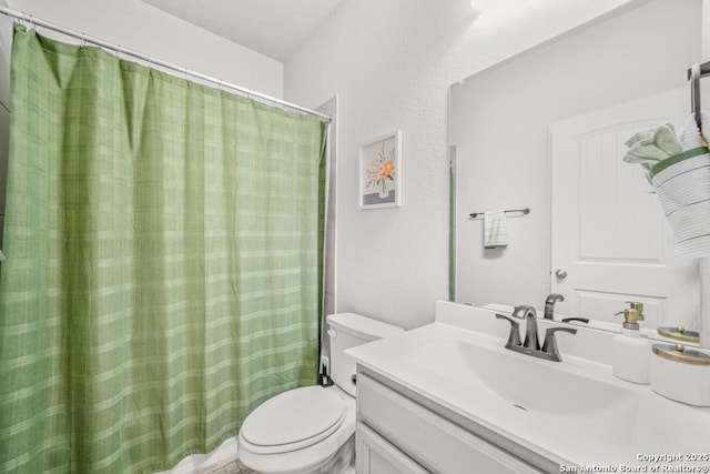 bathroom with vanity, a shower with shower curtain, and toilet