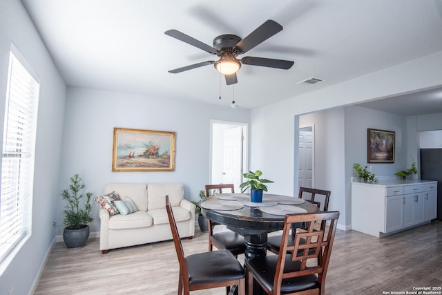 dining space with ceiling fan, plenty of natural light, and light hardwood / wood-style flooring