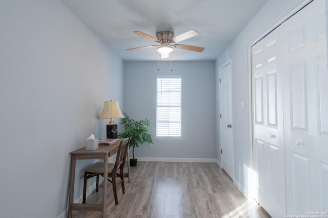 home office with light hardwood / wood-style flooring and ceiling fan