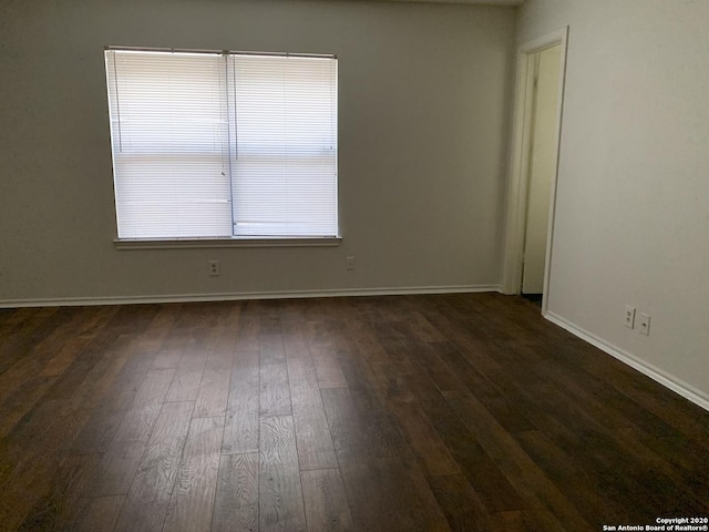 empty room with dark hardwood / wood-style flooring