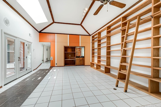 interior space featuring ceiling fan, french doors, high vaulted ceiling, crown molding, and light tile patterned floors