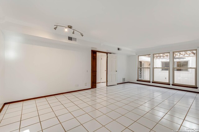 tiled spare room featuring a barn door