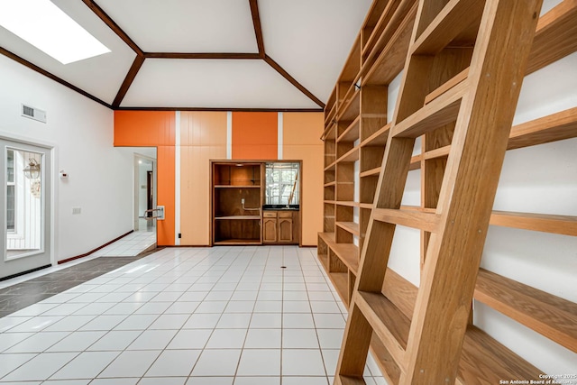 unfurnished living room featuring a healthy amount of sunlight, light tile patterned floors, and lofted ceiling