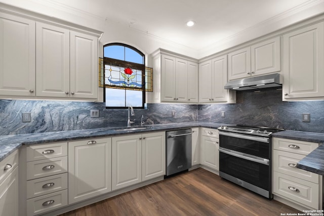 kitchen with backsplash, sink, dark hardwood / wood-style flooring, white cabinetry, and stainless steel appliances