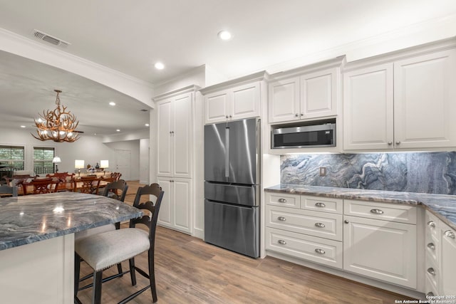 kitchen featuring white cabinets, backsplash, and stainless steel appliances